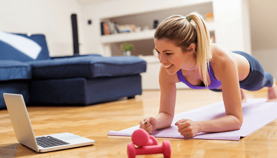 Woman working out while watching a show on the laptop